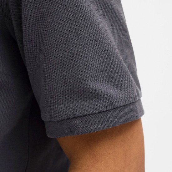 Close-up van de mouw van een donkergrijs poloshirt.