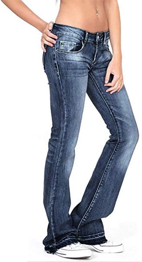 Close-up van een vrouw in donkerblauwe, uitlopende jeans met lage taille. De jeans heeft een stonewashed look en is van de zijkant gefotografeerd.