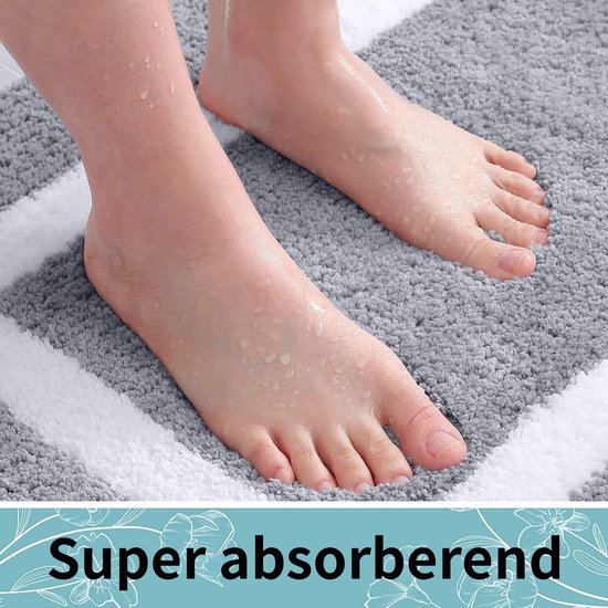 Voeten met waterdruppels op een grijs badkleed met witte strepen. Super absorberend.