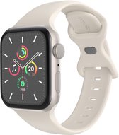 Crème siliconen bandje met gesp, bevestigd aan een smartwatch met een zilverkleurige kast.