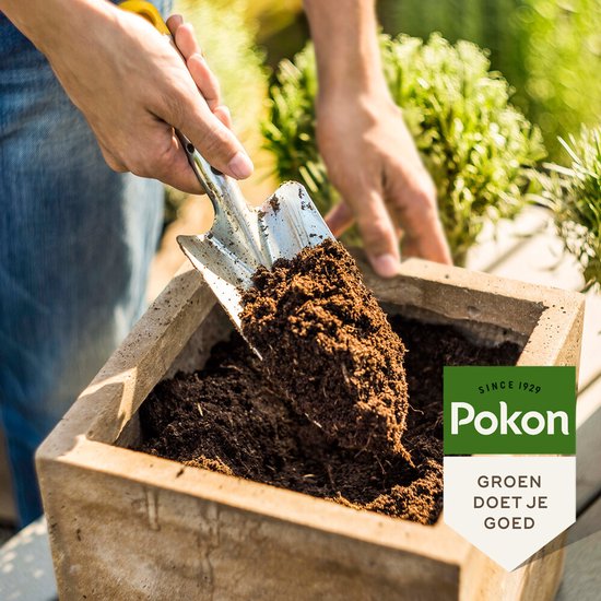 Potgrond van Pokon wordt met een schep in een houten plantenbak geschept.