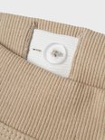 Detail van de tailleband van een beige joggingbroek met knoopsluiting.