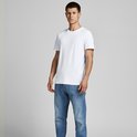 Man met wit T-shirt met ronde hals en spijkerbroek.