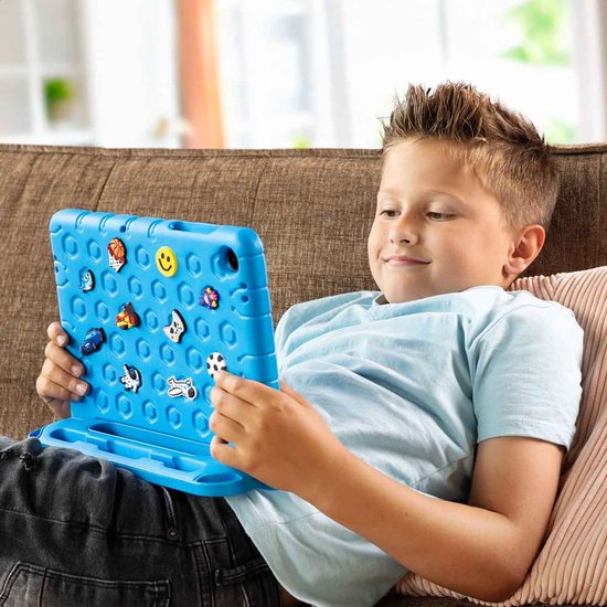 Jongen ligt op bank met blauwe tablet hoes met opdrukken, in gebruik als standaard.