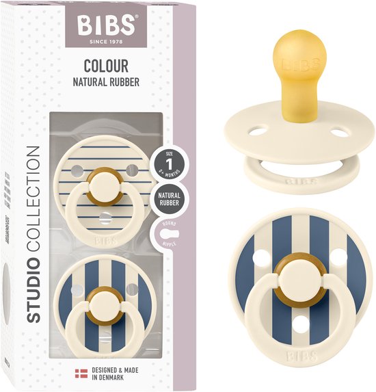 Verpakking met twee BIBS spenen, beide crème met marineblauwe strepen. Eén met ronde speen, op de verpakking staat 'Studio Collection'.