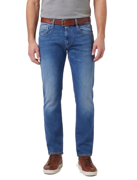 Man in een blauwe Replay Anbass Hyperflex jeans met lichte wassing, bruine riem en schoenen.