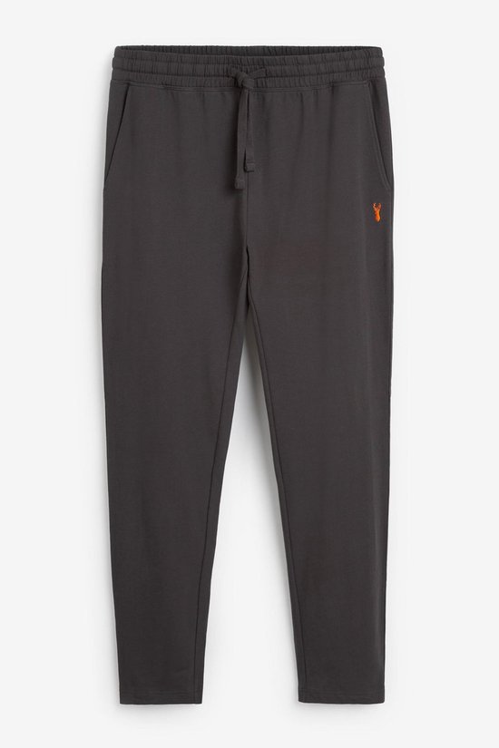 Grijze joggingbroek met oranje hertje geborduurd op de linkerheup, tunnelkoord en zak.