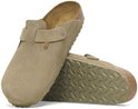 Een beige suède Birkenstock Boston slipper met een verstelbare gesp en een crêpezool. De slipper heeft een opengewerkt detail aan de zijkant.