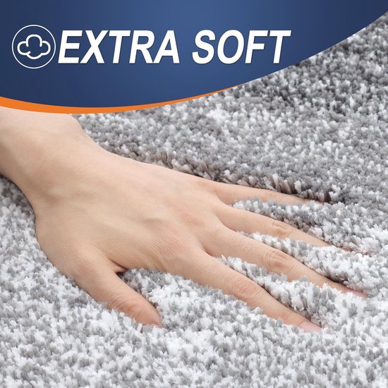 Hand op een zeer zachte, pluizige grijze badmat met de tekst 'EXTRA SOFT'.