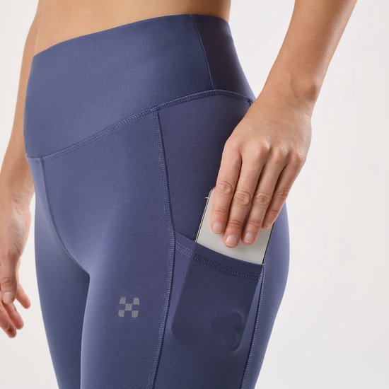 Paarse legging met steekzakken aan de zijkant, een telefoon erin.