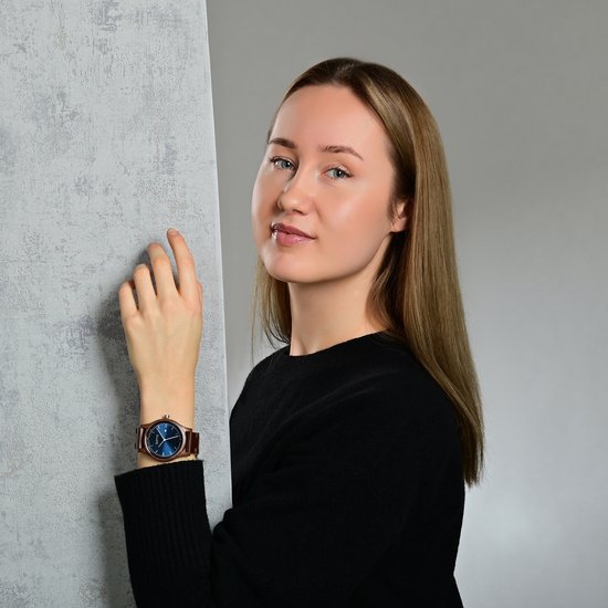 Jongedame met een Raptor horloge met blauwe wijzerplaat en houten band.