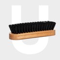 Brosse avec un manche en bois clair et des poils noirs denses.