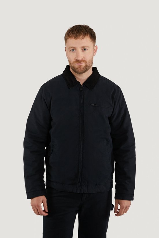 Man met donkerblauwe jas van Vintage Industries, met corduroy kraag en zwarte broek.