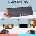 Zwarte docking station met oranje en blauwe accenten, toont poorten. Switch 2 console in desktop mode en tv mode met controller.