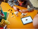Een meisje bouwt LEGO Dalmatiërs met een tablet, met twee Dalmatiërs en onderdelen.