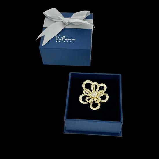 Gouden cosmosbloem broche met zirkonia in een blauw Victoria Valenza doosje.