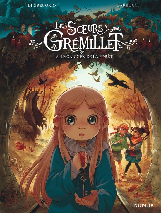 Titel: Les Soeurs Grémillet - S. Le gardien de la forêt. Een jong meisje met lang blond haar, blauwe jas en een sleutel in haar hand, kijkt naar de kijker. Achter haar lopen twee meisjes met rode en oranje sjaals. De scène speelt zich af in een herfstbos.