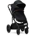 Zwarte Deryan kinderwagen met bruin lederen duwstang en grote kap.