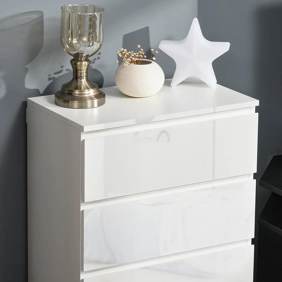 Bovenzijde van een witte ladekast met decoratie.