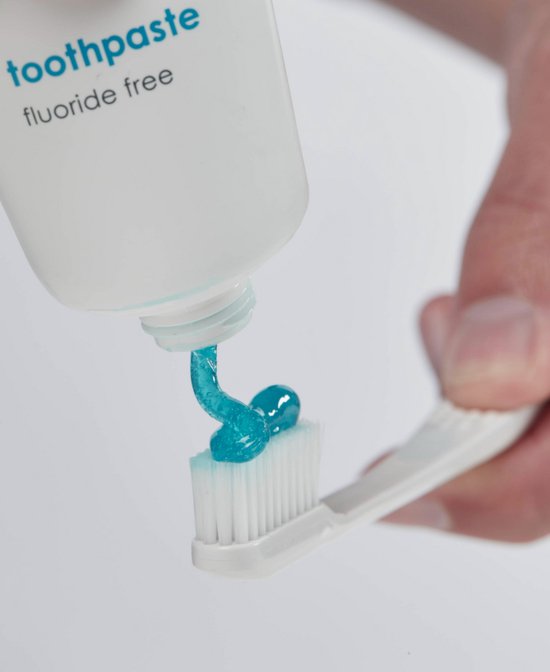 Blauwe tandpasta wordt uit een witte tube op een witte tandenborstel gespoten.