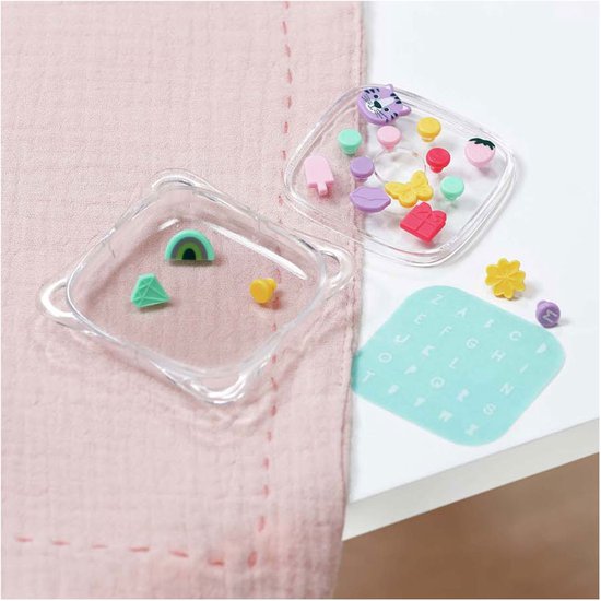 Set met accessoires: amuletten, letterkaart en transparante bakjes.