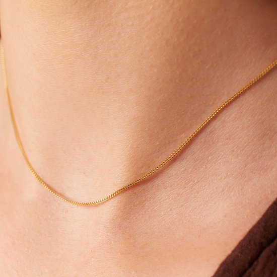 Sluiting van de gouden gourmet ketting op de huid.
