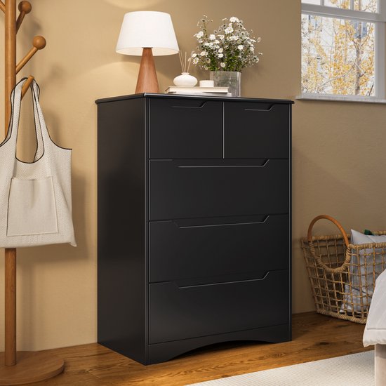 Commode noire à 5 tiroirs, avec un sac sur un portemanteau, une lampe et des fleurs sur le dessus.