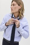 Man met lang blond haar in blauw-wit gestreept overhemd en zwarte das.