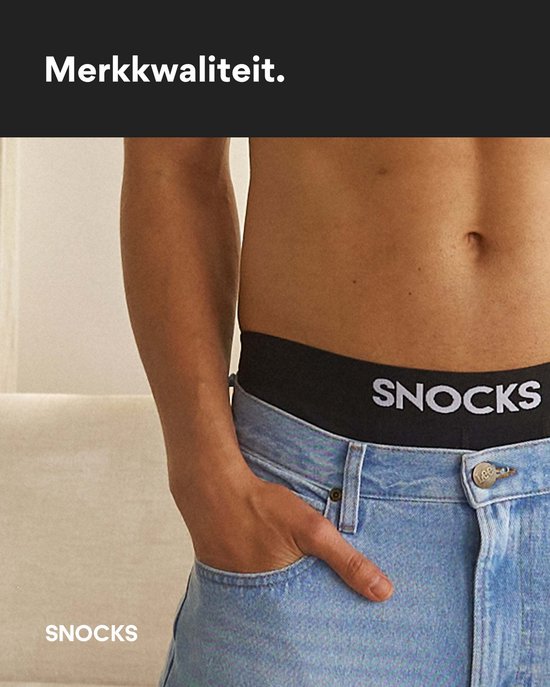 Close-up van de tailleband met SNOCKS logo op een zwarte boxershort, gedragen met spijkerbroek.