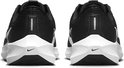 Zwarte Nike hardloopschoenen, achterkant, met witte zolen en Nike logo's.