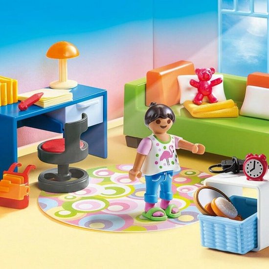 Speelgoedkamer met groen bankje, blauw bureau, kind, roze beer en veel accessoires.