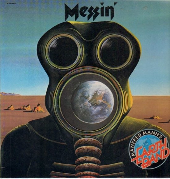 Een groen gasmasker met een afbeelding van de aarde in de lens. Tekst 'Messin' en 'Manfred Mann's Earth Band'. Woestijnlandschap op achtergrond.