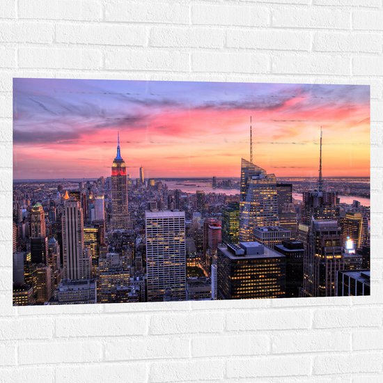 WallClassics - Muursticker - Uitzicht over de Stad New York bij Zonsopkomst - 105x70 cm Foto op Muursticker