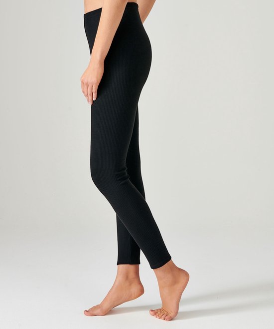 Zij-aanzicht van een zwarte geribde legging gedragen door een model.