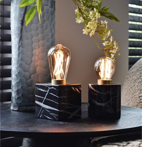 Twee tafellampen met zwarte marmeren voet en gouden fitting, elk met een gloeiende retro ledlamp.