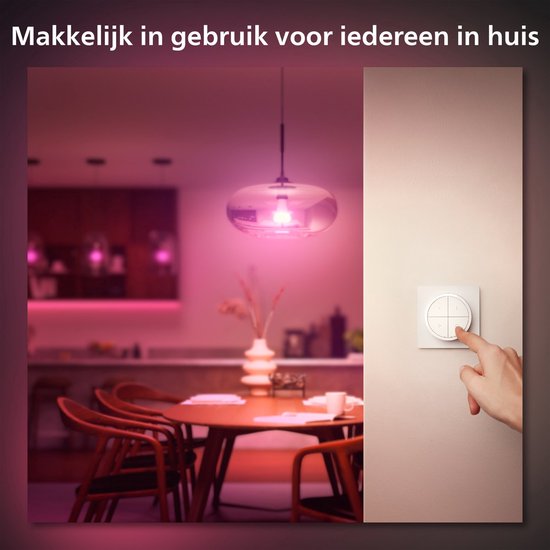 Een hand draait aan de knop van een Hue Tap Dial Switch, naast een eettafel met roze verlichting.