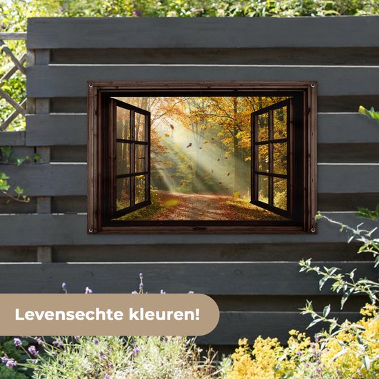 Open raam met boslandschap in herfstkleuren, hangend aan een donkergrijze schutting.