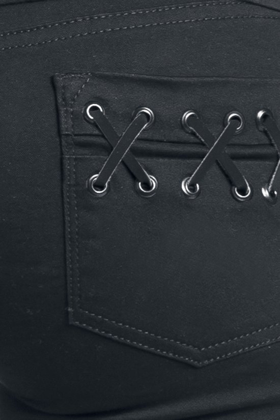 Detail van een zwarte jeans met kruislingse vetersluiting op de achterzakken.
