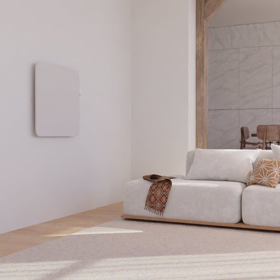 Witte paneelradiator hangend aan een witte muur in een woonkamer.