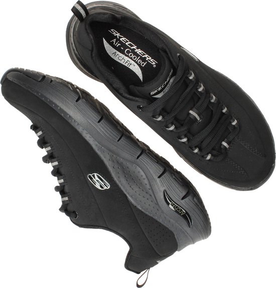 Twee zwarte Skechers Arch Fit sneakers, een liggend, met Air-Cooled binnenzool.