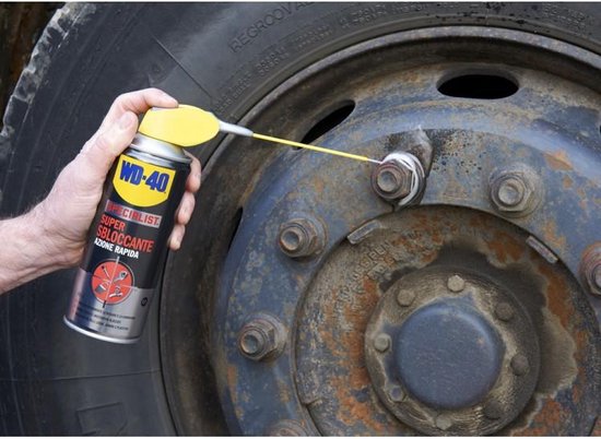 Man spuit WD-40 Specialist Super Kruipolie op de wielmoeren van een vrachtwagen.