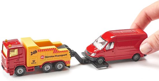 Hand houdt een gele breakdown truck met '24h Siku Service-Transport' opdruk vast, die een rood personenbusje op een plateau vervoert.