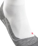Detail van een witte FALKE sportsok met grijze versteviging op de hiel en rode details.