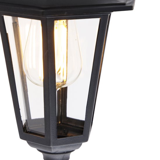 Close-up van de glazen kap van de zwarte wandlamp met zichtbaar gloeilampje.