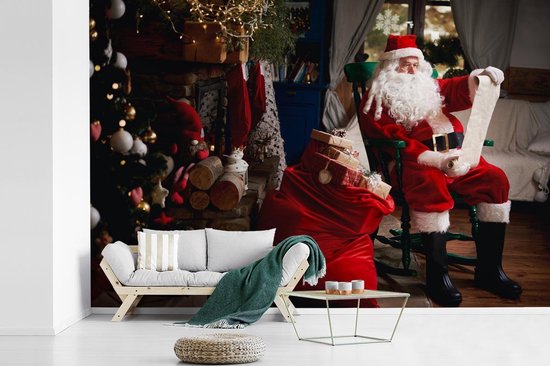Bol Com Fotobehang Vinyl Kerstman Zittend In Een Stoel Met Zak Vol Geschenken Breedte 600 Cm