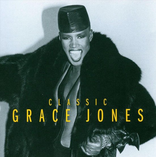 Grace Jones draagt een zwarte bontjas en hoed. Tekst: CLASSIC GRACE JONES.