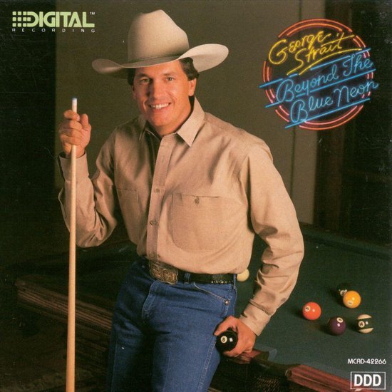 George Strait met een Stetson hoed, beige overhemd, spijkerbroek, riem en biljartkeu met een biljartbal.