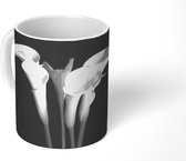 Mok - Een close up van calla lily-bloemen op een zwarte achtergrond - 350 ML - Beker