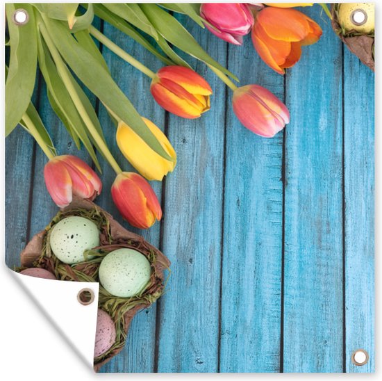 Paaseieren en kleurrijke tulpen tijdens Pasen op een houten ondergrond