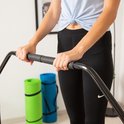 Detailopname van de handen van een vrouw op de gewatteerde handgreep van een fitness trampoline.